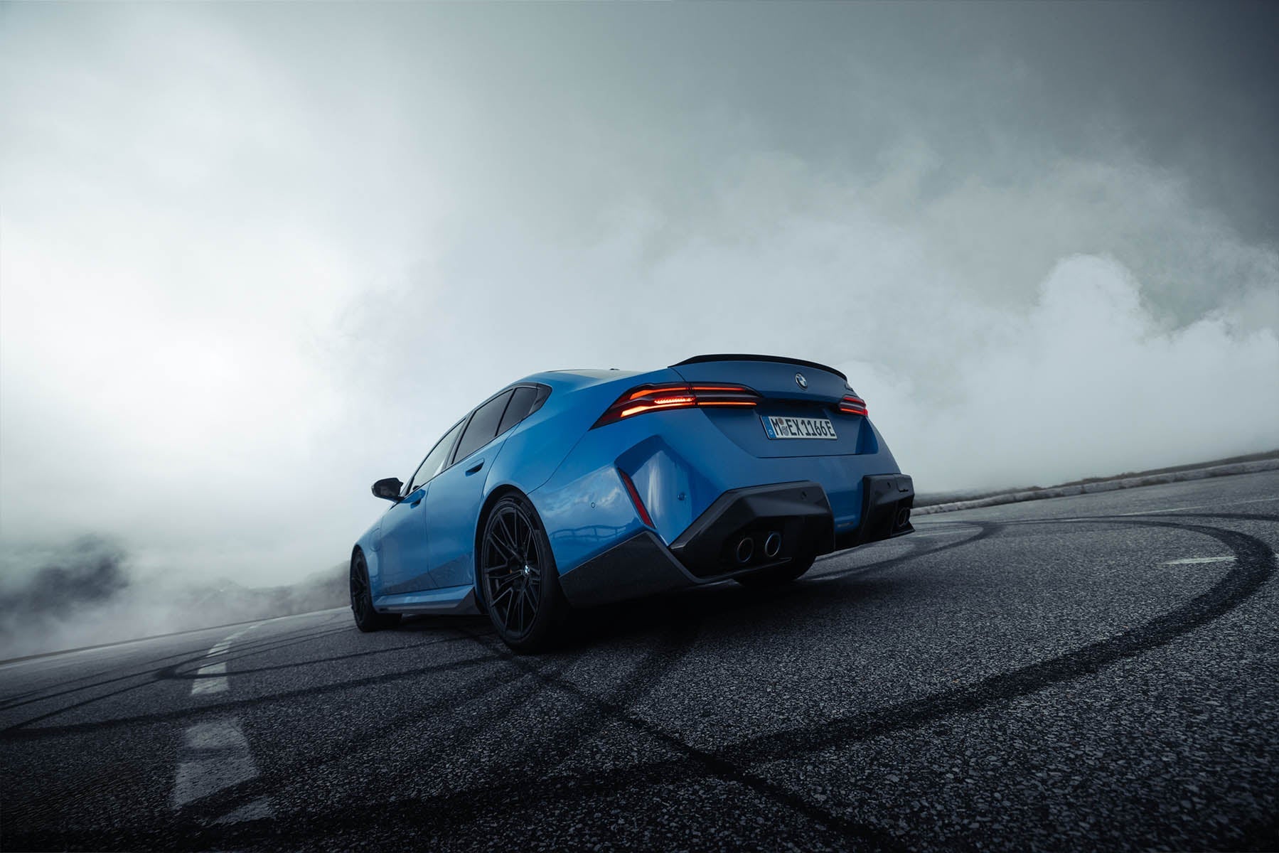 Blue BMW M drifting on a mountain road, edited with ATMOS Pro Suite smoke and fog overlay for a cinematic effect