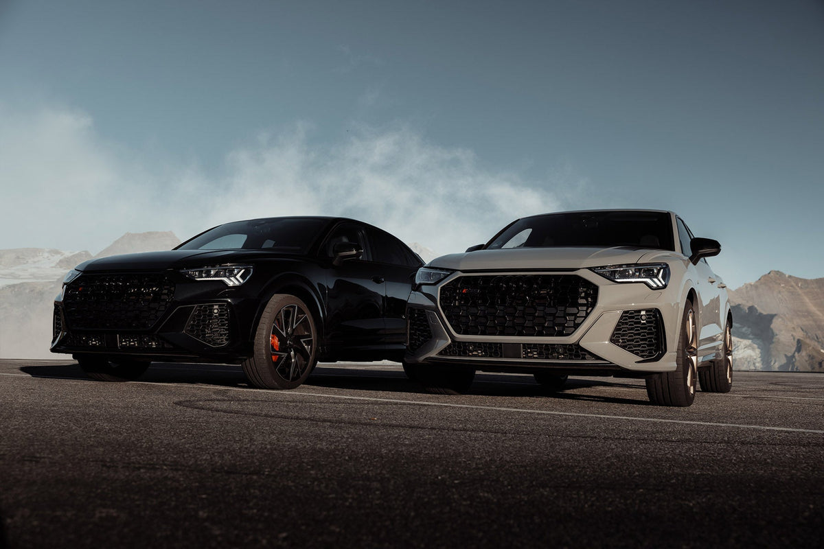 Two Audi SUVs on a mountain road, edited with atmospheric fog to add mood to the exterior shot