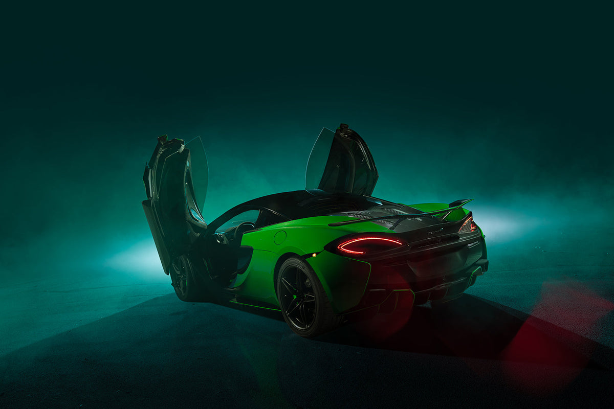 Green sports car with butterfly doors open in a smoky studio setting with dramatic teal and red lighting, edited with the Photoshop Master Bundle overlays