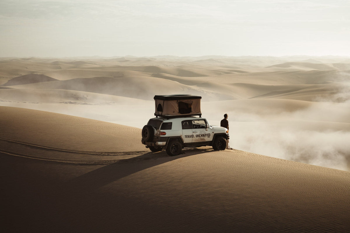Off-road vehicle with rooftop tent parked on a desert sand dune, edited with Vapor Pro atmosphere overlay and Terra Tones Lightroom presets for a dusty, cinematic look